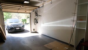 A garage with a car parked outside, a bicycle mounted on the wall, and a ladder leaning against the wall. - Savoy Villas 4D, 3BD Vail Condo With Garage (Vail)