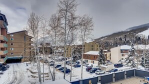 A residential area with a swimming pool, parked cars, and buildings with balconies. - Westwind 203 1BD Platinum Condo in Lionshead Village With A/C (Vail)