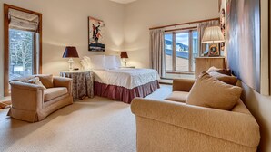 A bedroom with a bed, two bedside tables, a sofa, and a window with curtains. - Treetops 5C, 3BD Ski-in Ski-out Condo (Vail)