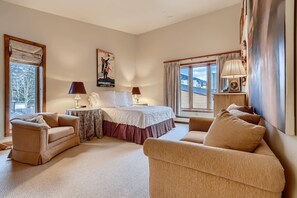 A bedroom with a bed, two bedside tables, a sofa, and a window with curtains. - Treetops 5C, 3BD Ski-in Ski-out Condo (Vail)