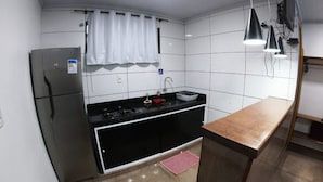 Una cocina equipada con refrigerador, estufa, lavaplatos y encimera de madera.