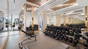 Kuntosali, jossa on peiliseinät, painonnostovälineitä ja monenlaisia käsipainoja.
