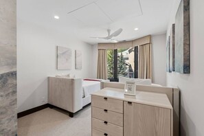 A hotel room with a bed, a desk, a chair, a ceiling fan, and artwork on the walls. - Luxury Ski condo W/Resort Amenities | Walk to lift (Beaver Creek)