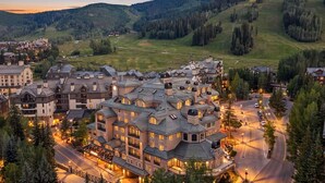 Un resort con varias construcciones, caminos y un paisaje montañoso al fondo.