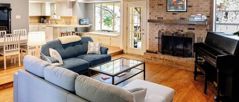 A modern living room with a sofa, coffee table, fireplace, and a television.