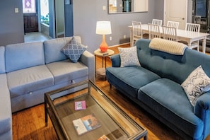 A living room with a sofa, a coffee table, and a lamp.
