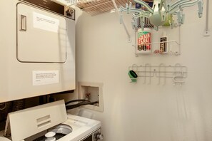 A bathroom with a sink, a mirror, a towel rack, and a shelf with toiletries. - Snow Fox 201, 2BD Modern Vail Condo (Vail)