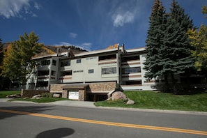 A multi-story building with a stone facade, balconies, and a sign reading 'Snow Fox.' - Snow Fox 201, 2BD Modern Vail Condo (Vail)