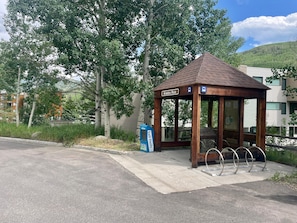 A wooden bus stop with a shelter, a sign reading 'Simba Run,' and a blue vending machine. - Snow Fox 201, 2BD Modern Vail Condo (Vail)