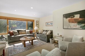A living room with a sofa, armchairs, a coffee table, and a painting on the wall. - Snow Fox 201, 2BD Modern Vail Condo (Vail)
