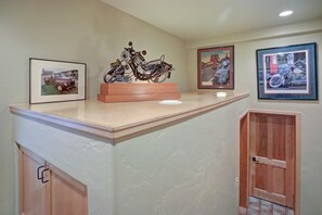 A reception area with a wooden counter, framed motorcycle pictures, and a door. - Creekside Penthouse, 3BD + Loft in Vail Village (Vail)