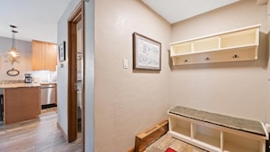 A modern kitchen with wooden cabinets, a built-in dishwasher, and a pendant light. - Westwind 309 1BD 2BA Platinum Condo in Lionshead Village (Vail)