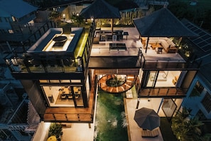 A multi-level outdoor living space with a pool, seating areas, and a circular water feature. - Sri Laksmi Villa Seminyak (Seminyak)