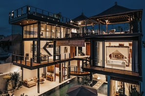 Une maison moderne à plusieurs niveaux, dotée d’un vaste espace de vie, d’une chambre avec un lit à baldaquin et d’une terrasse sur le toit.