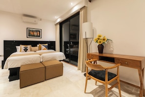 Une chambre d’hôtel moderne équipée d’un lit, d’un bureau, d’une chaise et d’un vase contenant des tournesols.