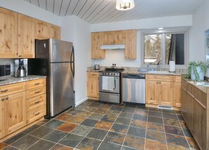 A modern kitchen with wooden cabinets, a stainless steel refrigerator, a built-in oven, and a dishwasher. - Gore Circle Chalet, 4BD Private East Vail Home (Vail)