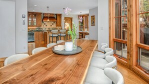 A spacious dining area with a wooden table, chairs, and a vase with flowers. - 796a Potato Patch - 4BD Private Home in Vail (Vail)