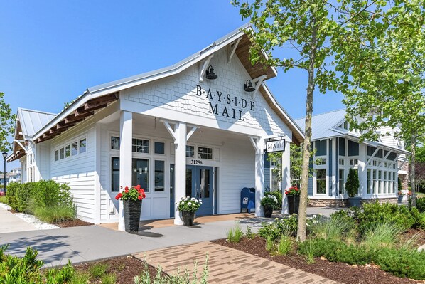 A Bayside Mail post office with a white exterior, large windows, and a covered entrance area.