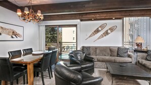 Ein modernes Wohnzimmer mit Esstisch, Ledersesseln, einer Couch und einem Couchtisch.