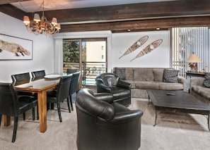 Ein modernes Wohnzimmer mit Esstisch, Ledersesseln, einer Couch und einem Couchtisch.