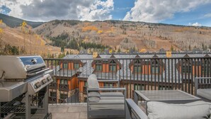 A balcony with a grill, outdoor seating, and a view of a mountainous landscape. - Altus 305, 3BD Vail Village Condo With Views (Vail)