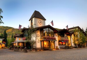 Ein Hotel mit einem Uhrturm, amerikanischen Flaggen und Außenbestuhlung.