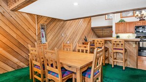 A dining area with wooden furniture and a green carpet. - Ridgepoint 187, 3BD Townhome in Beaver Creek (Avon)