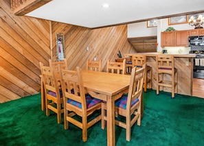 Ein Essbereich mit Holzmöbeln und einem grünen Teppich.