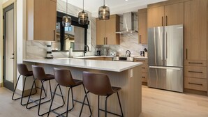 Eine moderne Küche mit Marmorarbeitsplatte, Edelstahlgeräten und Holzschränken.