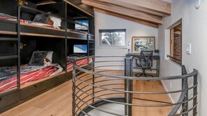 A bunk bed with a TV, a desk with a chair, and a spiral staircase. - Wall Street 302, 1BD + Loft Condo in Vail Village (Vail)