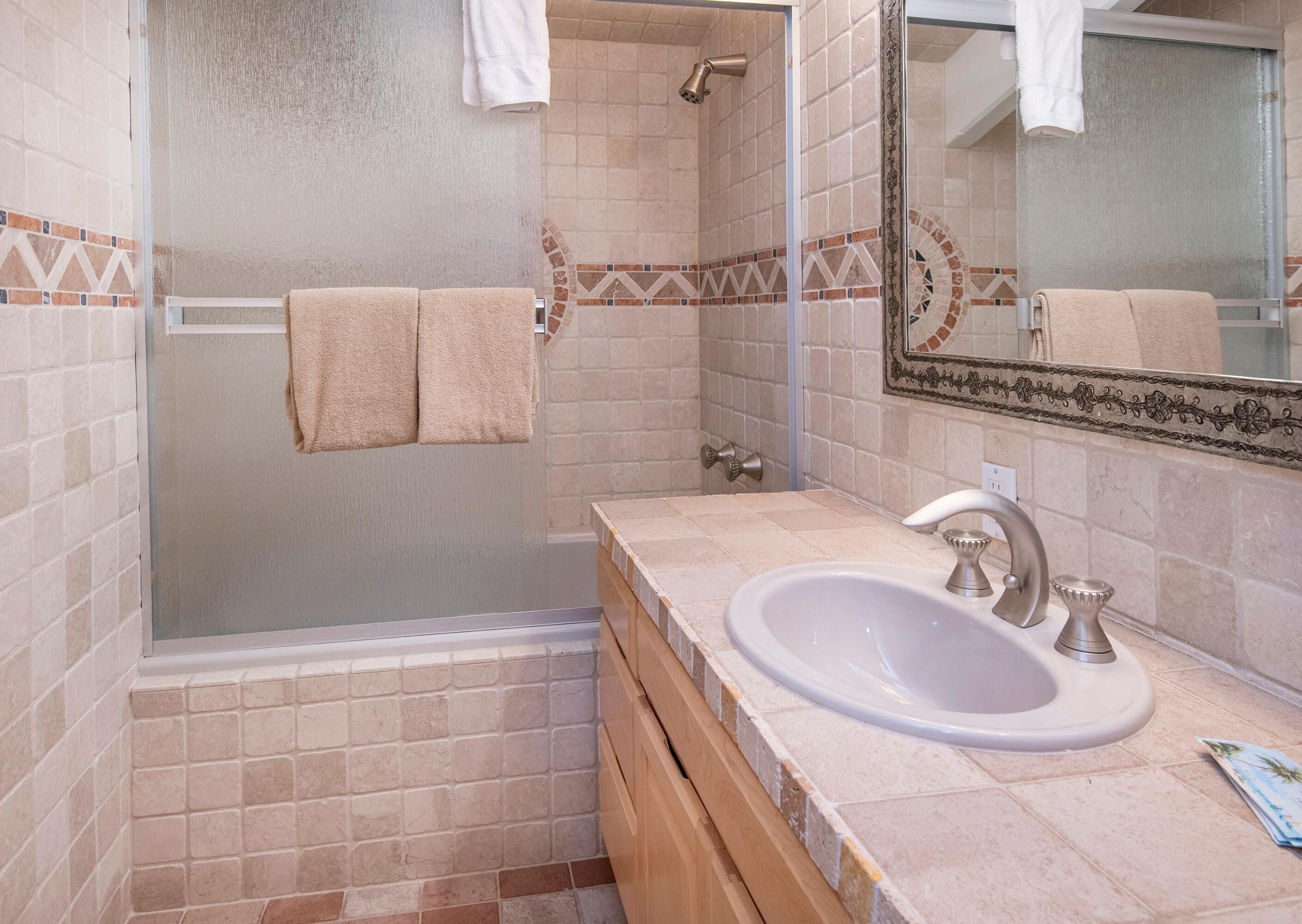 A bathroom with a bathtub, a sink, and a shower.