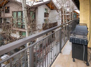 A balcony with a grill, a metal railing, and a view of neighboring buildings. - Wall Street 307, 1BD + Loft Condo in Vail Village (Vail)