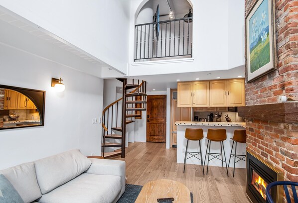 A loft-style living area with a staircase, kitchen, and bar seating. - Wall Street 307, 1BD + Loft Condo in Vail Village (Vail)