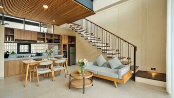 A modern interior with a dining area, kitchen, and a staircase.