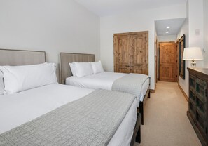 A hotel room with two beds, a wooden wardrobe, a lamp, and a carpeted floor. - Beaver Creek Landing A204, 3BD 3.5ba Ski In/out Condo (Avon)