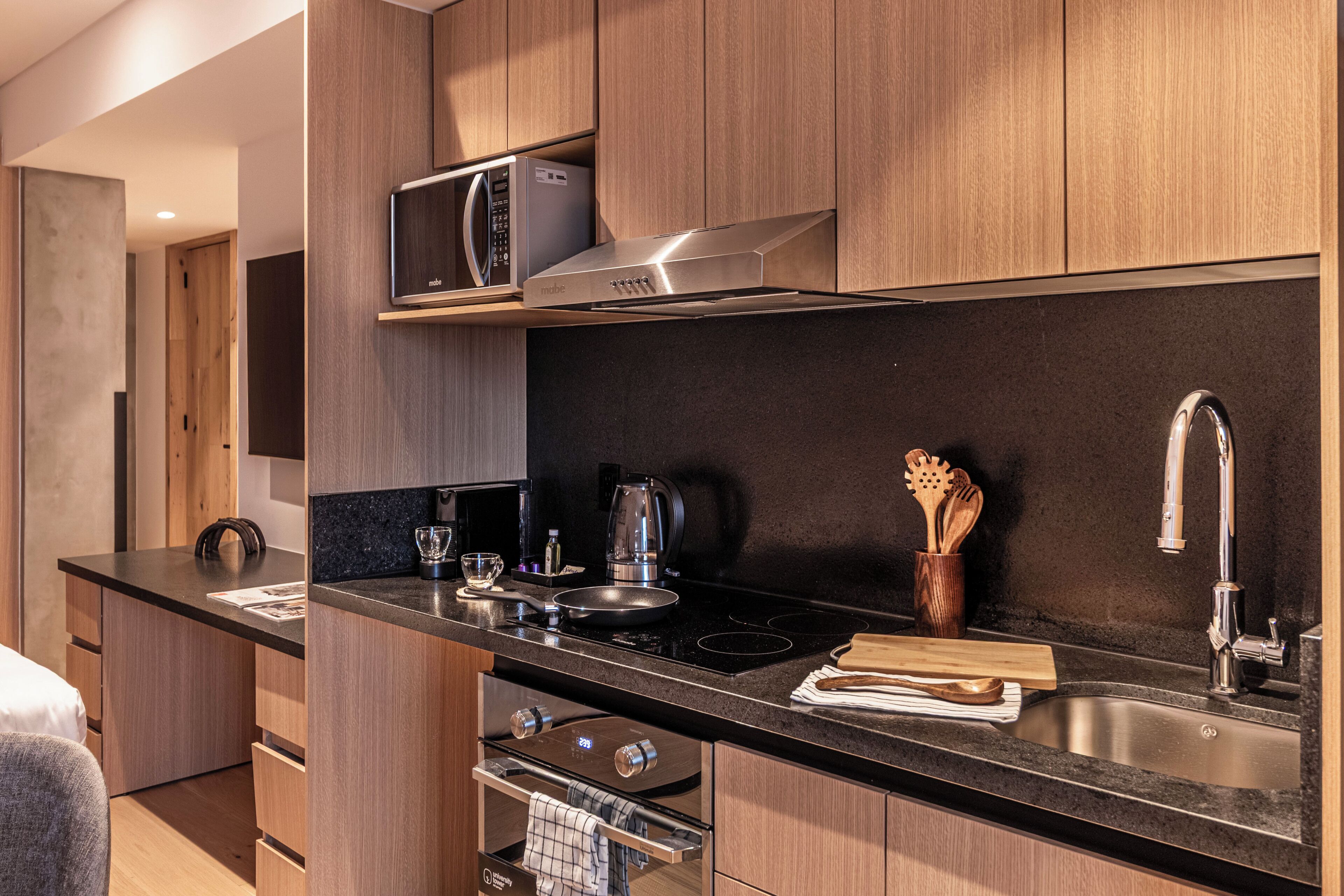 Una cucina moderna con forno a microonde, fornello e lavello.