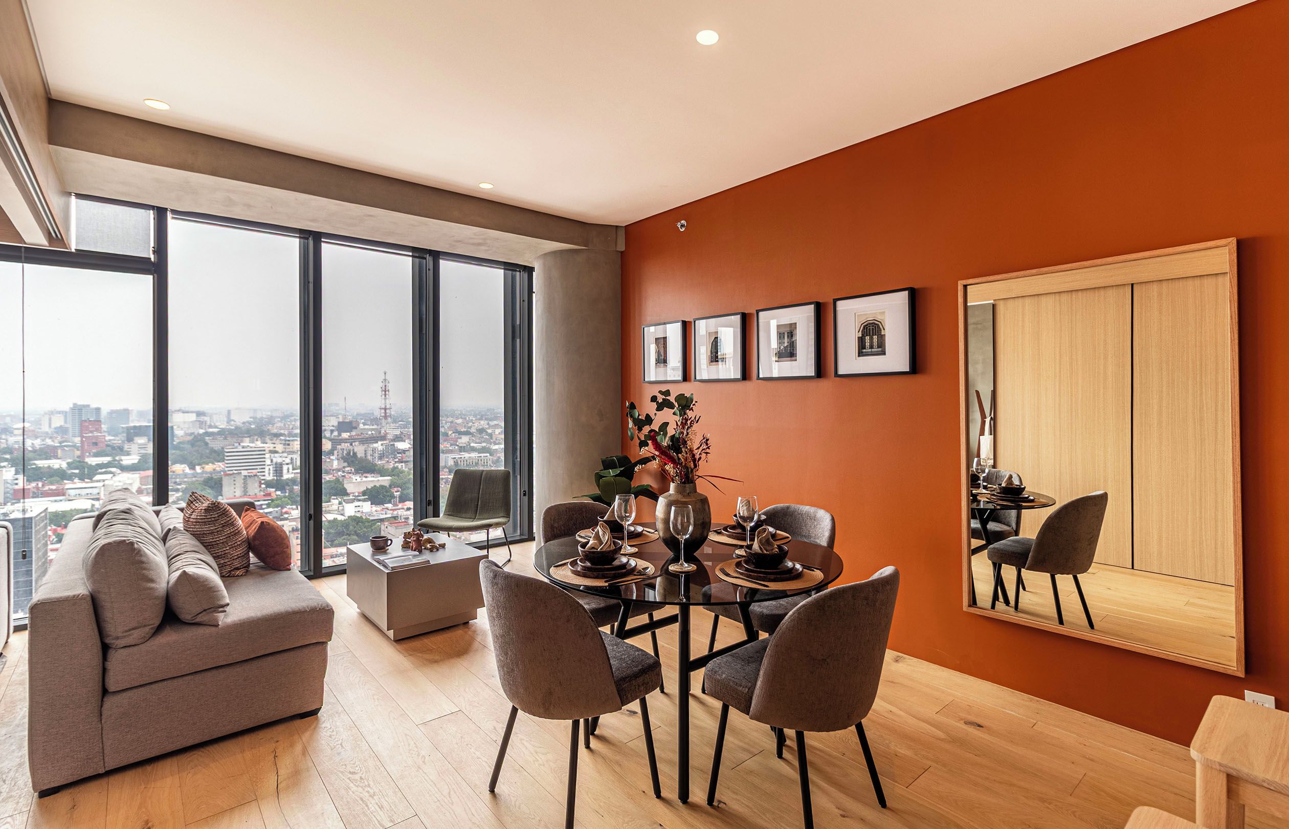 Een moderne woonkamer met een eethoek, grote ramen en uitzicht over de stad.