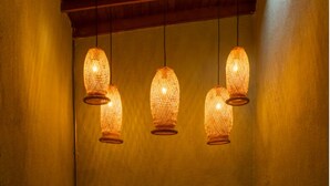Un muro con tre lampade appese e un cancello in metallo con decorazioni.