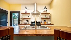 Una cocina con una isla central, estufa y lavamanos.