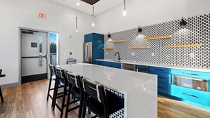 A modern kitchen with a central island, blue cabinets, and a patterned backsplash. - Free Gated Parking • Music Row Condo • Pool • Rooftop Club Room with Pool Table (Nashville)