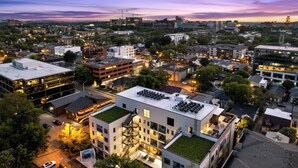 A modern building with a rooftop garden, multiple floors, and a parking area. - Free Gated Parking • Music Row Condo • Pool • Rooftop Club Room with Pool Table (Nashville)