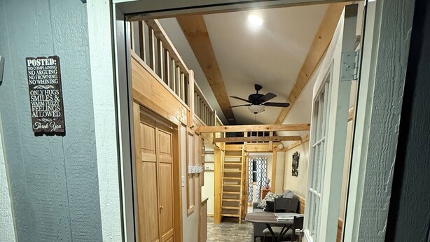 A hallway with a wooden door, a mat, a ceiling fan, and a dining area with a table and chairs. - Cute, comfy, clean, safe, quiet, welcoming community in Madison. Pet-friendly (Madison)