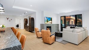 Uma sala de estar moderna com lareira, um sofá e um espaço de jantar com cadeiras.