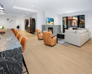 Ein modernes Wohnzimmer mit Kamin, einer Couch und einem Essbereich mit Stühlen.
