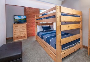 A bunk bed with a television on a wooden dresser, a small desk, and a bench. - Vail International 111, 2 BD Lionshead Village Condo (Vail)