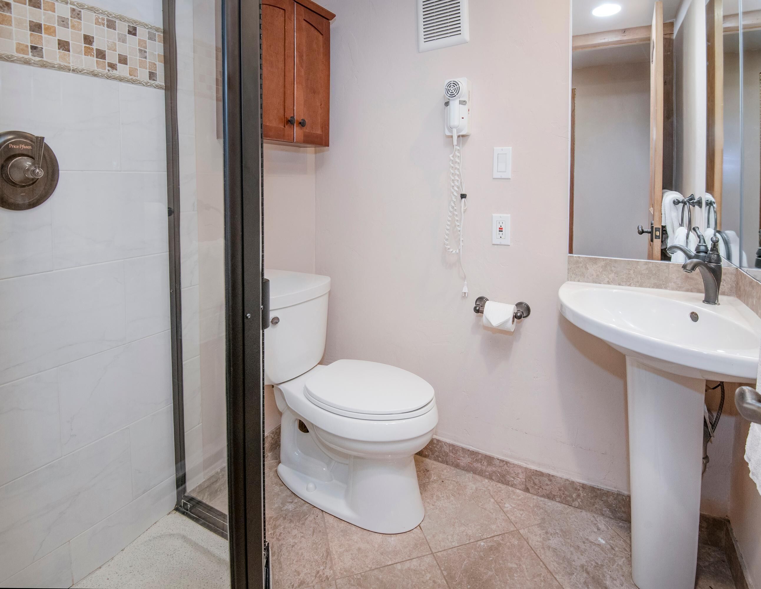 Un baño con inodoro, ducha y lavamanos.