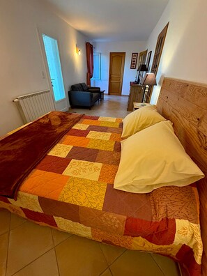 Une chambre avec un grand lit, un canapé, un bureau et une fenêtre.