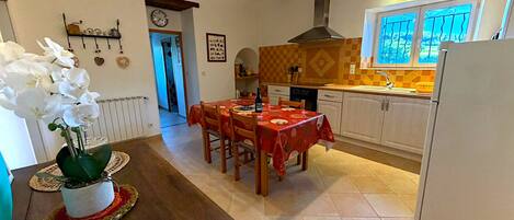 Una cocina con mesa, sillas, un refrigerador y una ventana con vistas.