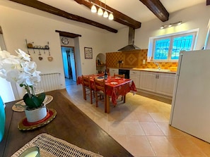 Une cuisine équipée d’une table à manger, de chaises, d’un réfrigérateur et d’une fenêtre donnant sur un beau paysage.