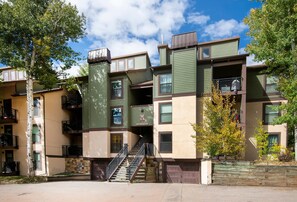 A multi-story residential building with a central staircase, balconies, and a small garden area. - Breakaway West 222, 2BD Vail Condo (Vail)
